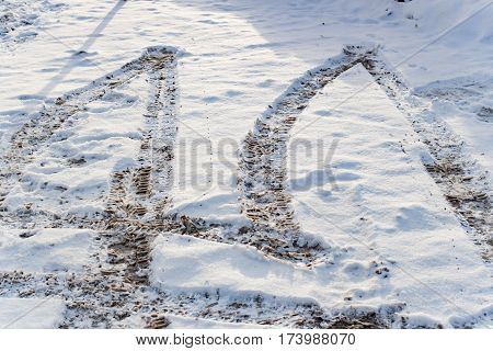 Snow and slush footprints on the road in winter