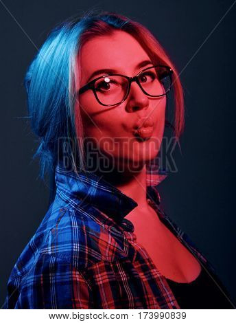 Blonde Girl In A Checkered Shirt And Eyeglasses. Kising Lips.red And Blue Lights.portrait.