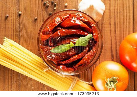 Italian spaghetti with ingredients for cooking pasta on a wooden table.
