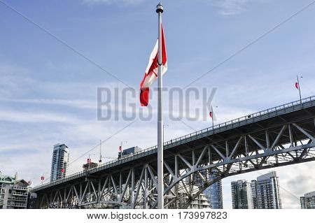 British Columbia,Canada-March 21 2017: Canada Flag and the Bridge in the back located in Granville Island at Vancouver,BC Canada