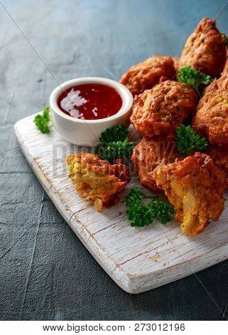 Crispy Onion Bhajis With Sweet Chilli Sauce On White Wooden Board