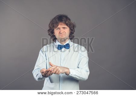 Man In Shirt And Tie Shows Outstretched Hand With Open Palm, Index Finger Pointing At Palm. Upset Ma