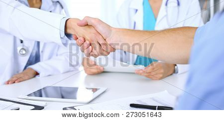 Two Doctors Shaking Hands To Each Other At Meeting. Teamwork And Agreement In Medicine