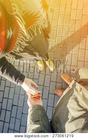 First Person View Of Couple Holding Hands. Loving Couple Holding Hands While Walking At Sunset. Apol