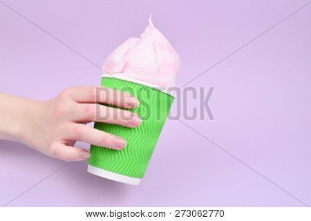Bright Pink Candy Cotton In Plastick Cup In Woman Hand On Lilac Background.