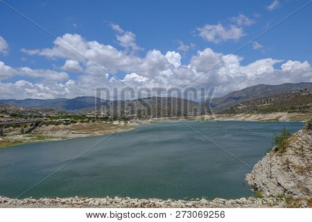 Germasogia Dam And Resevoir, A Landscape View With Beautiful Clouds Over The Cypriot Mountains.