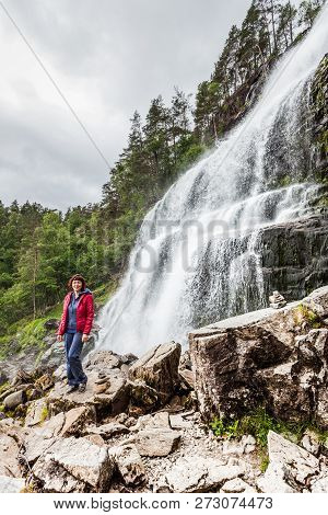 Tourist Woman At Svandalsfossen In Norway, Powerful Waterfall In Norwegian Mountains. National Touri