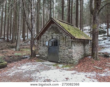 Small Wooden Chapel On Snowbound Frosty Glade In Snowy Frozen Forest. Winter Wonderful Scenery In Ge