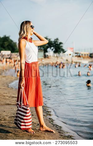 Beautiful Young Woman With Bag On The Beach