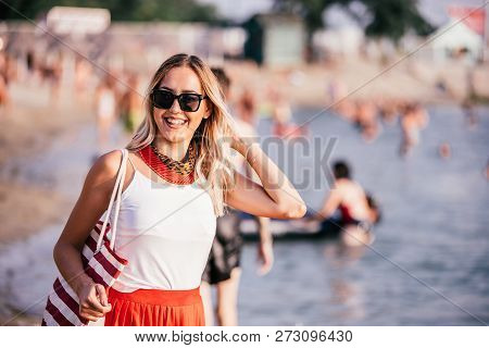 Smiling Young Woman With Bag On The Beach