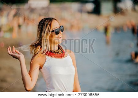 Woman In Sunglasses Laughing While Resting At Beach