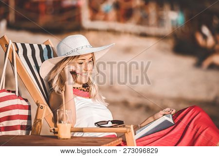 Young Woman Talking On A Mobile Phone On The Beach