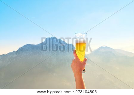 Hands Lifting Draft Beer Glass And Happy Enjoying Harvest Time At Outdoor On Beautiful Mountain Scen