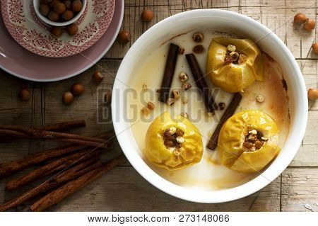Baked Apples With Raisins, Hazelnuts And Cinnamon On Wooden Background. Rustic Style.