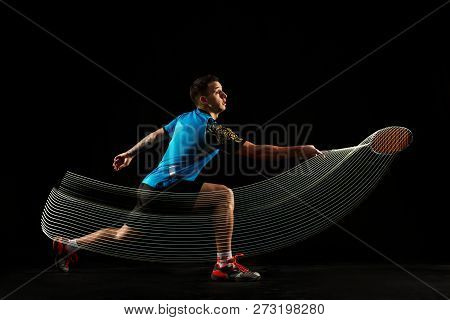Young Man Playing Badminton Over Black Studio Background. Fit Male Athlete Isolated On Dark With Led