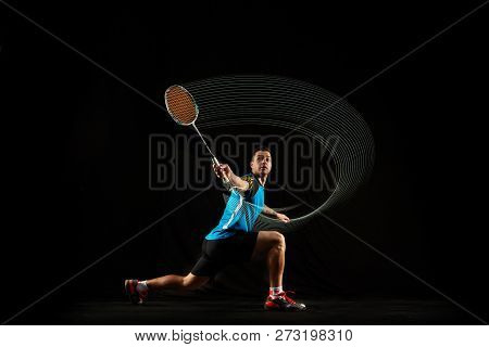 Young Man Playing Badminton Over Black Studio Background. Fit Male Athlete Isolated On Dark With Led