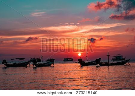 Long Tail Boat Silhouettes At Sea During Sunset In Ko Tao Thailand