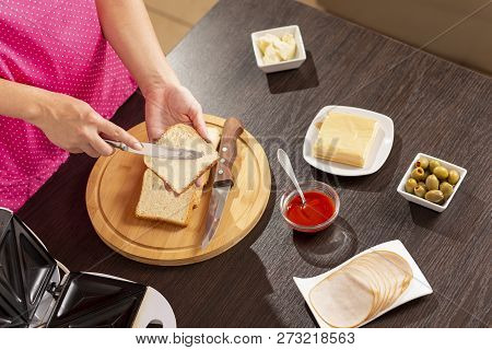 Detail Of Female Hands Spreading Butter Over A Bread Slice; Woman Making Hot Sandwiches In A Sandwic