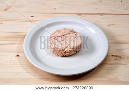 Solid White Albacore Tuna Fish Up Close On White Plate Still Shaped Like The Can It Came In On Woode