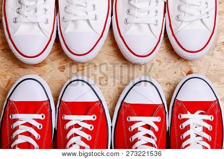 White And Red Sneakers On A The Wooden Background.