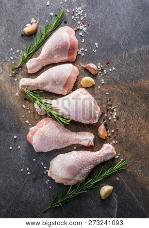 Chicken legs with spices and salt  ready for cooking on cutting board.