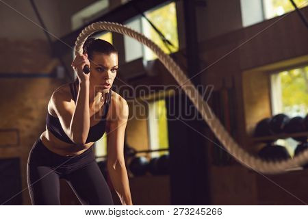 Fit, Sporty And Athletic Sportswoman Working In A Gym. Woman Training Using Battle Ropes. Sports, At