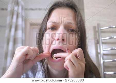 Sleepy Woman Woken With A Hangover And Brushes Her Teeth With Dental Floss In The Bathroom.