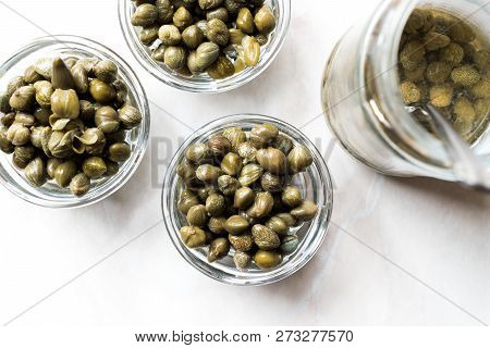 Jar Of Capers In Glass Bowl.