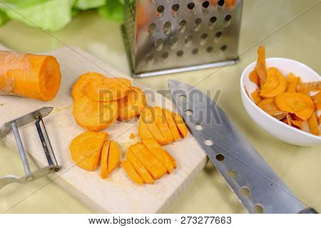 Fresh Carrot Grated On A Metal Kitchen Grate. Vegetables Prepared For Salad With A Meal On The Kitch