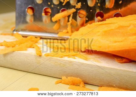 Fresh Carrot Grated On A Metal Kitchen Grate. Vegetables Prepared For Salad With A Meal On The Kitch