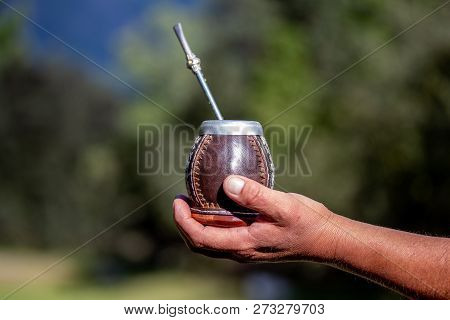 Man Holding Calabash Yerba Mate In Nature. Travel And Adventure Concept. Latin American Drink Yerba 