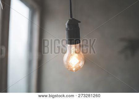 Retro Vintage Light Bulb With Led Technology Bult-in On Warm Light Yellow Tint And Black Background 