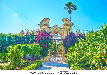 Naxxar, Malta - June 14, 2018: The Carved Stone Gates Of Palazzo Parisio Garden In Lush Greenery, On