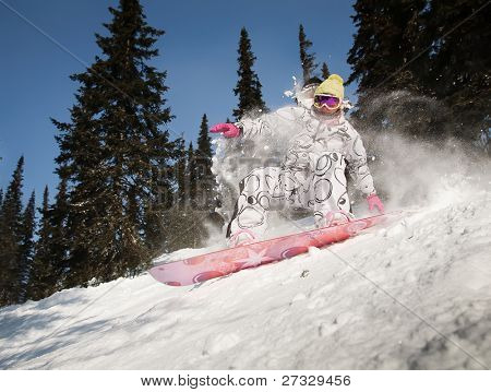 Snowboardista skoky vzduchem s tmavě modrou oblohou v pozadí