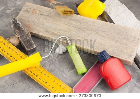 Stone And Old Hammer With Wooden Handle And Nail And Metal Nail Puller And Yellow Ruler And Brown Pl