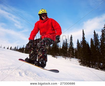 Snowboardista skoky vzduchem s tmavě modrou oblohou v pozadí