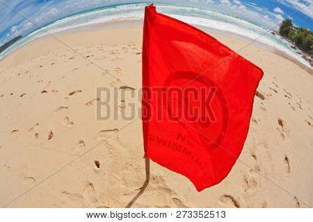 Red warning flag at beach in fish-eye view. Phuket, Thailand. 