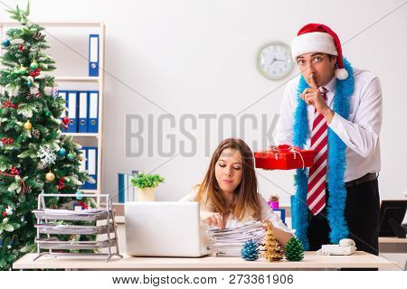 Colleagues exchaing christmas presents in office