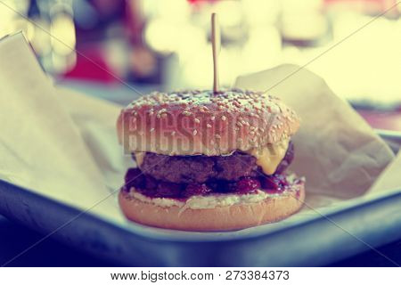 Hamburger with cherry berry sauce, close-up, toned inage