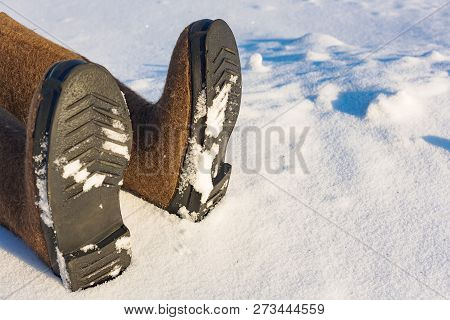 Human Legs In Warm Felt Shoes On The Side Of The Snow.  Place To Copy Information About Frostbite Or