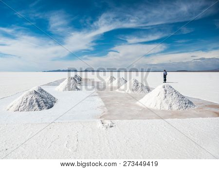 Salt worker in sunshine scenery of area with salt banks in Salar de Uyuni in Bolivia