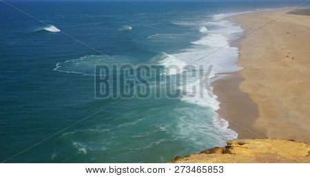 Rough Waves Touching Coast At Nazare In Portugal