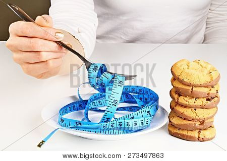 Woman With Measuring Tape And Fork Showing You How To Diet By Losing Weight Stock Photo