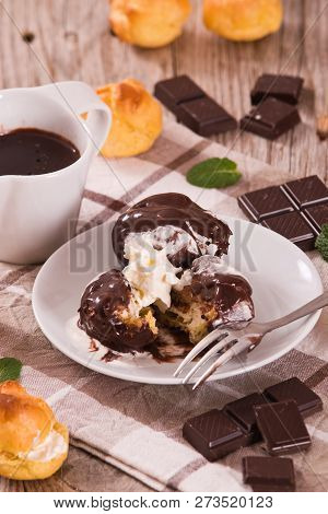 Chocolate Profiteroles With Whipped Cream On White Dish.