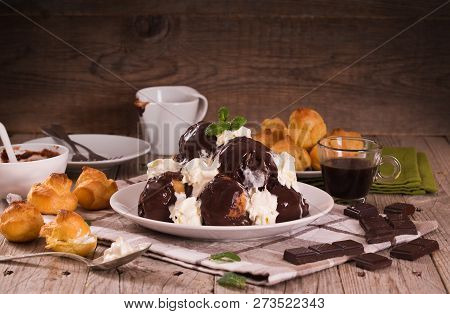 Chocolate Profiteroles With Whipped Cream On White Dish.