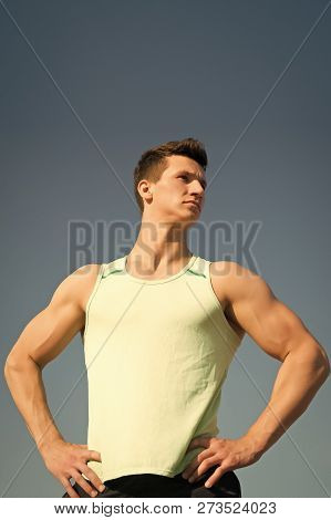 Athlete In Green Tshirt On Sunny Day. Man Bodybuilder Posing On Blue Sky. Workout And Training. Spor