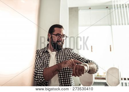 Delighted Nice Man Using His Modern Watch