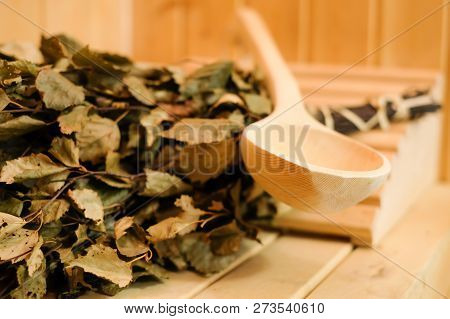 Sauna Accessories Close Up In Traditional Finnish Or Russian Sauna, Birch Broom And Wooden Scoop. Re