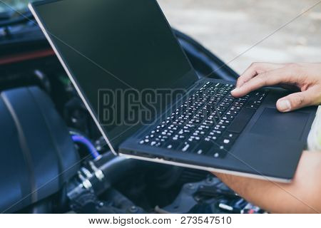 Close Up Engineer  Mechanic Using Electrnoic Diagnostic Equipment To Tune A Car.