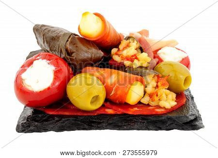 Group Of Tapas Snacks On A Slate Square Isolated On A White Background